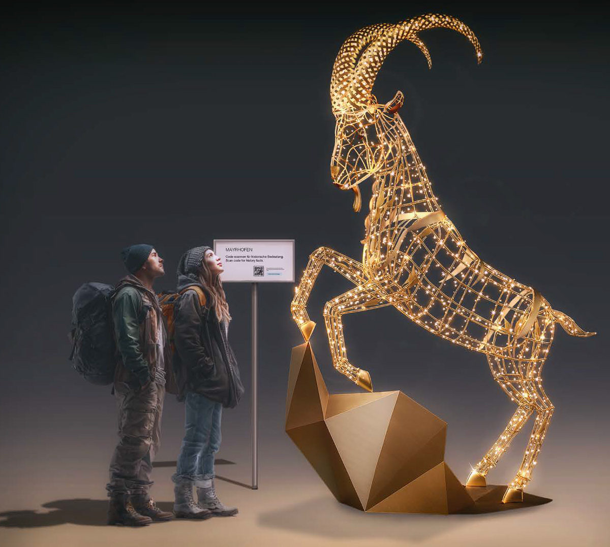 Zwei Wanderer stehen vor einer leuchtenden Steinbock-Lichtskulptur am Fotopoint „6 Orte, 6 Plätze“ in Mayrhofen im Zillertal.