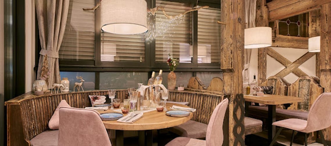 Das Bild zeigt das Logo von Berg & Tal, das auf einer Wand angebracht ist. Das Logo ist von altem, rustikalem Holz eingerahmt, was ihm einen traditionellen und gemütlichen Charakter verleiht.