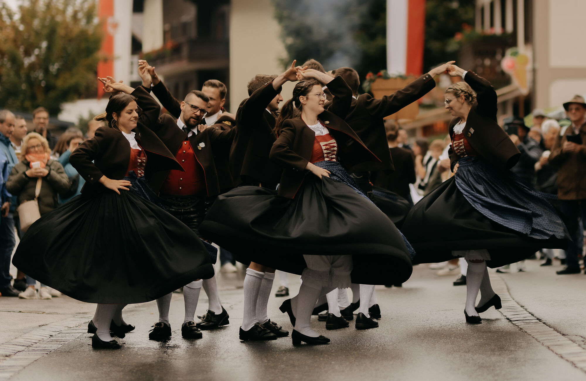 Schuhplattlergruppe Sonnwendler beim Zillertaler Bauern- und Musikherbst: Tänzerinnen und Tänzer in traditioneller Tracht führen gemeinsam einen schwungvollen Volkstanz auf.