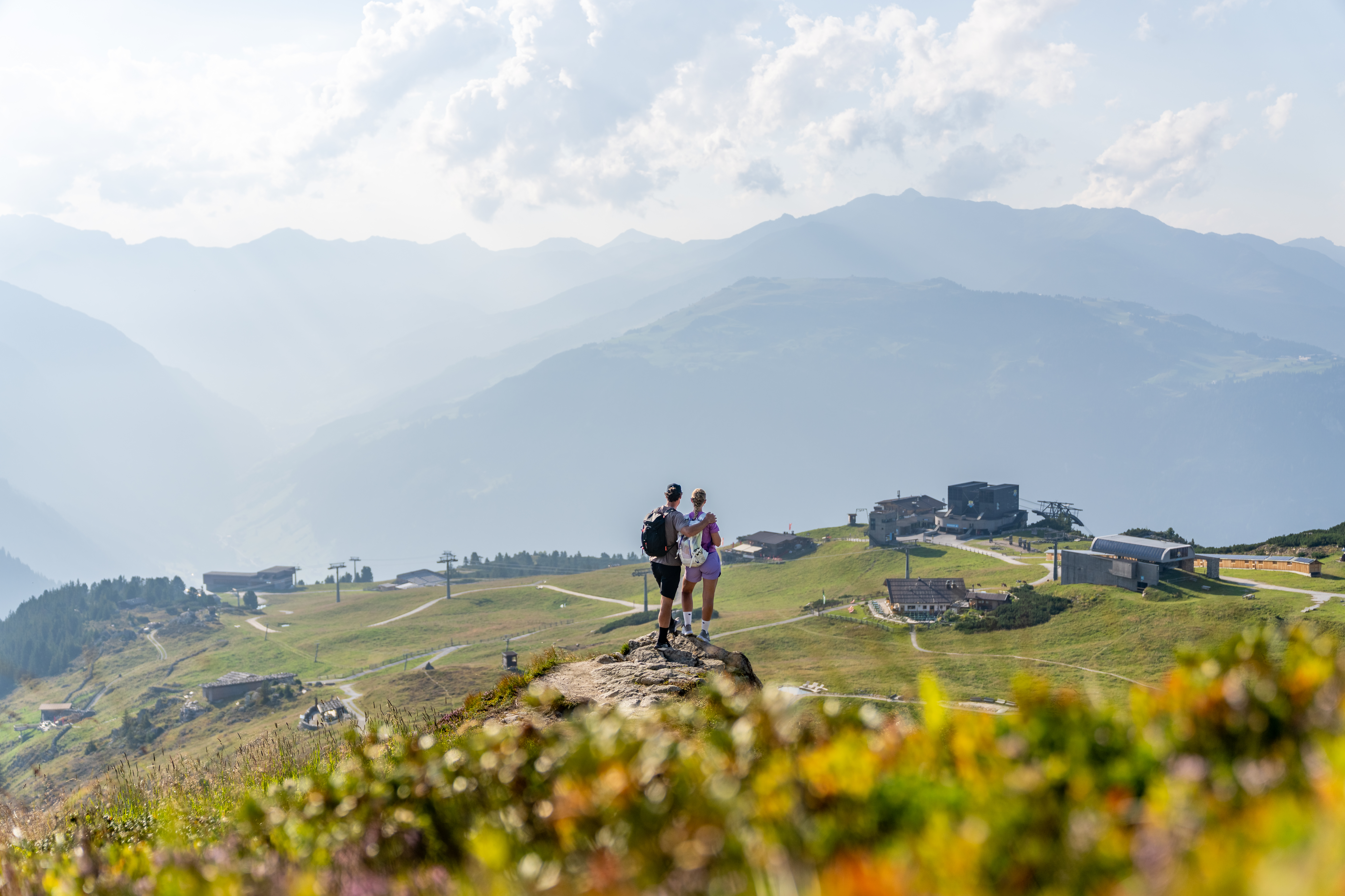 A couple stands on Mount Ahorn in the Zillertal, overlooking the mountain landscape.