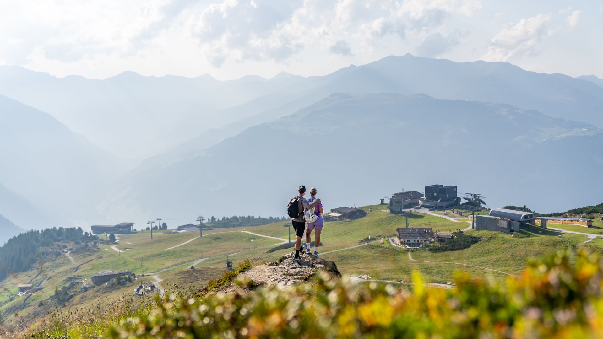 A couple stands on Mount Ahorn in the Zillertal, overlooking the mountain landscape.
