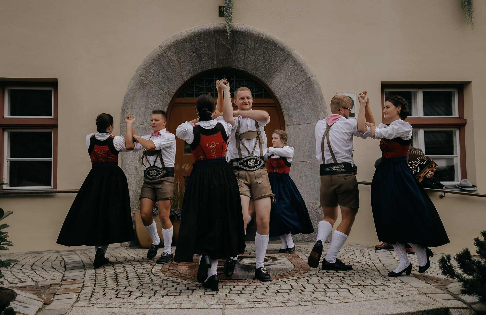 Schuhplattler-Gruppe VolXtonza beim Zillertaler Bauern- und Musikherbst: Frauen und Männer in traditioneller Tracht tanzen gemeinsam vor einem historischen Gebäude.