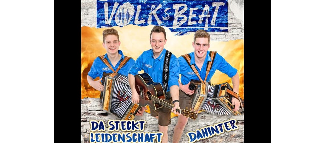 Das Bild zeigt die Gruppe Volksbeat in blauen T-Shirt und Instrumenten sowie einem Schriftzug über der Gruppe.