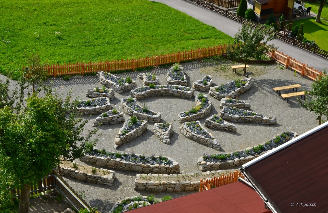 Schwendauer Pfad - Kräutergarten Kräutergarten in Form eines stilisierten Sterns mit Steinbeeten und Sitzgelegenheiten am Schwendauer Pfad in Tirol, Station 12 „Kräutergarten“, fotografiert von Andreas Tipotsch.