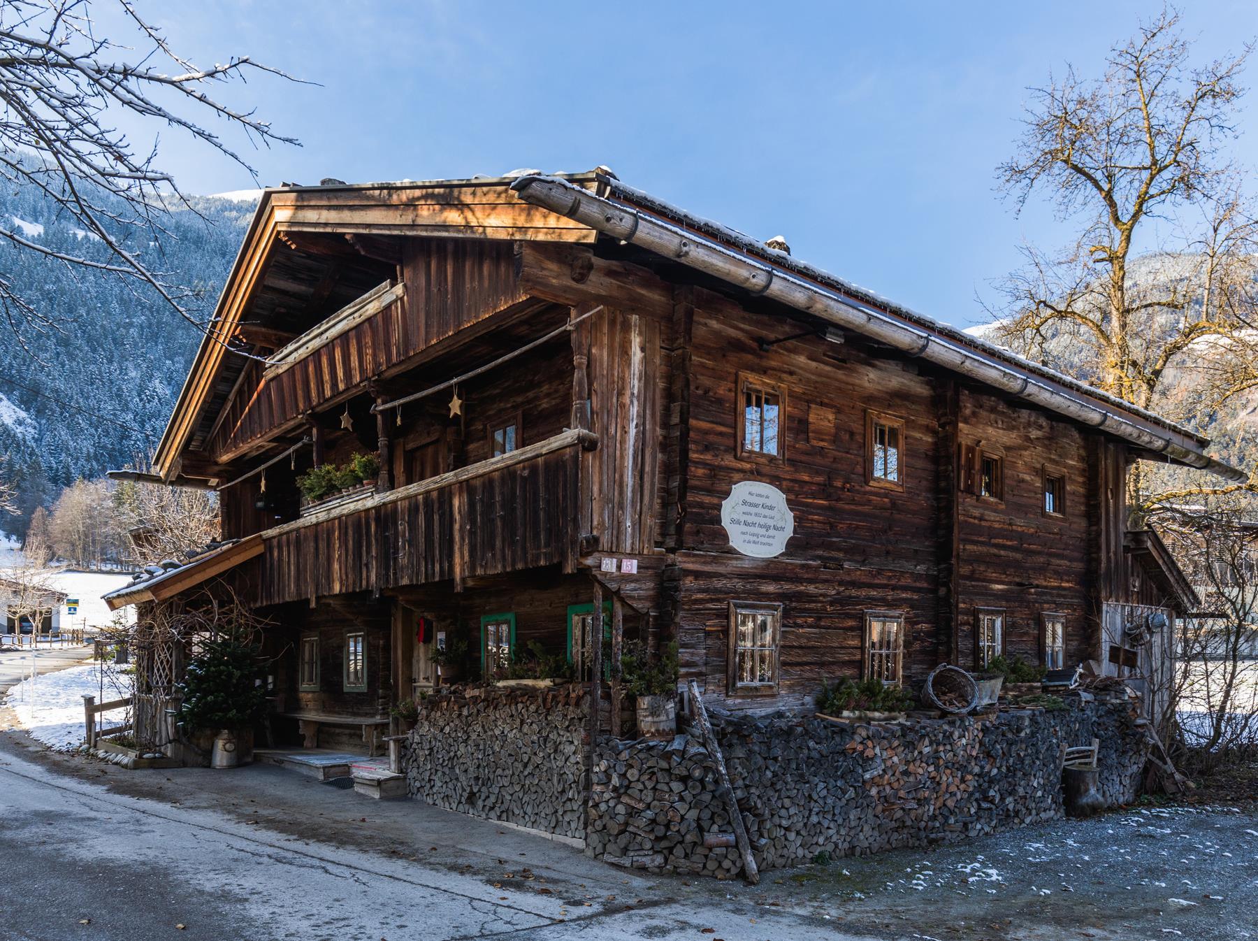 The picture shows the Strasserhäusl from the outside in winter, with a blue sky in the background.