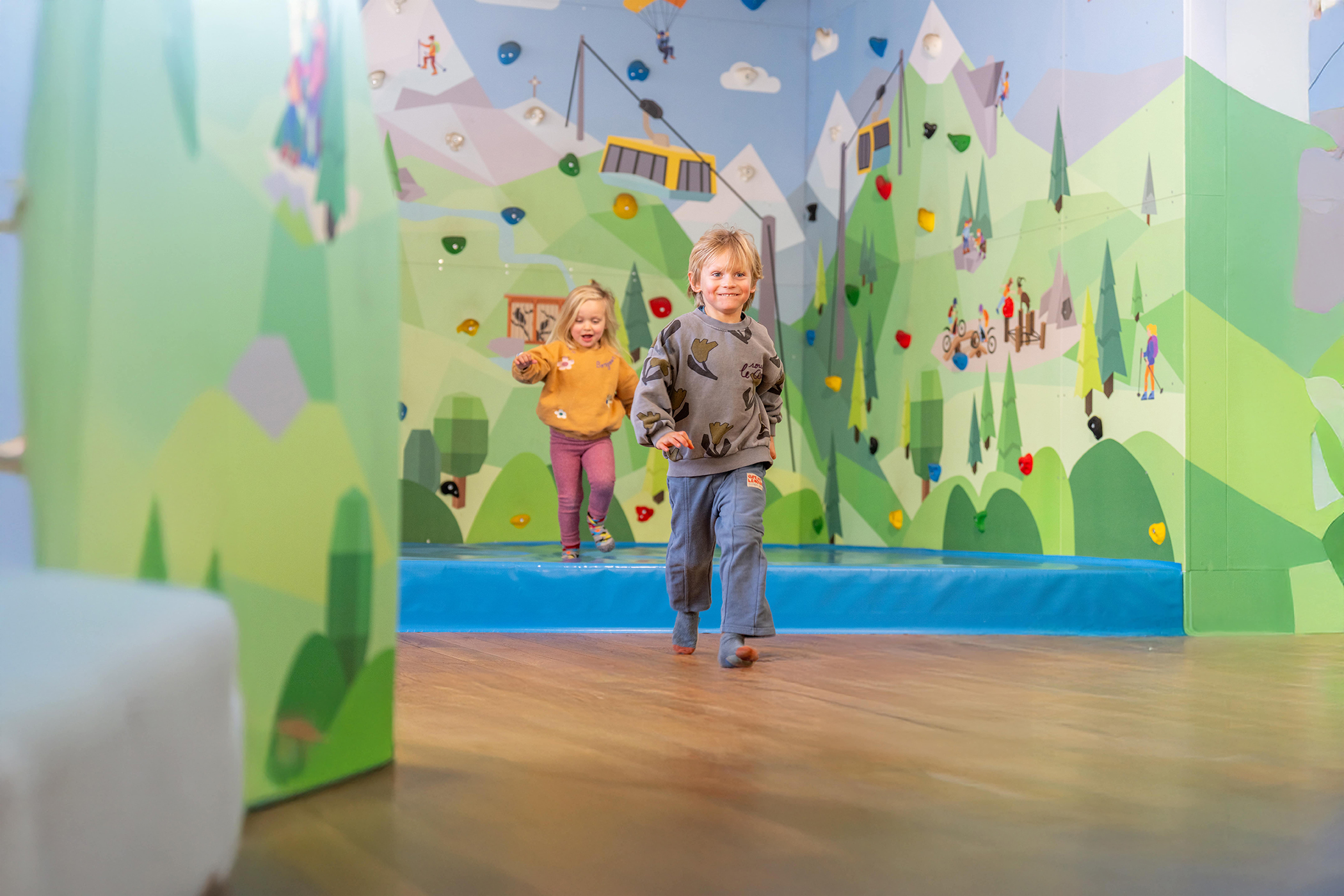 Kinder spielen vor der großen Kletterwand in der AlbertAdler SpieleWelt by Ravensburger am Ahorn