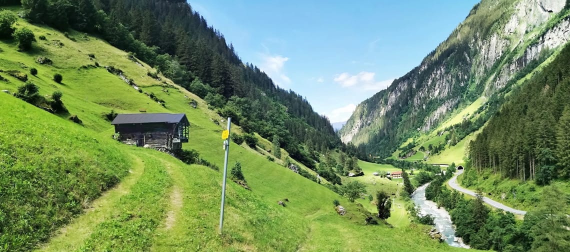 Eine Wiese mit Blick in das Zemmtal, man sieht Berge und eine kleine Hütte