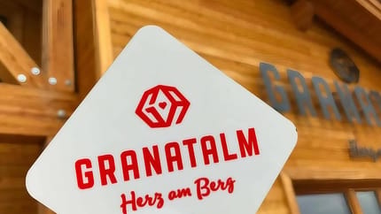 Das Bild zeigt die Granatalm am Penken mit dem Logo in roter Schrift im Vordergrund.