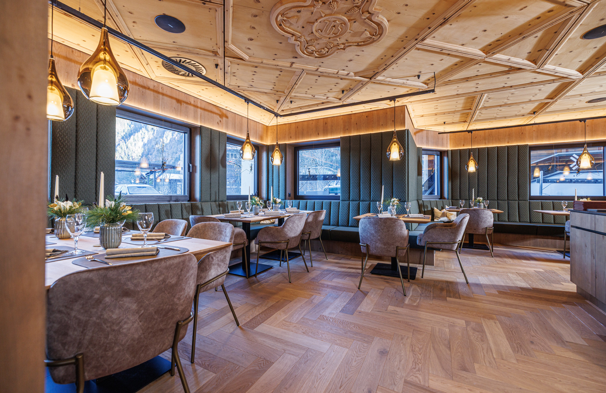 Restaurant im Hotel Brücke in Mayrhofen: gemütlicher Gastraum mit Holzboden, gedeckten Tischen, gepolsterten Sitzbereichen und traditioneller Holzdecke - Genussherbst-Partnerbetrieb.