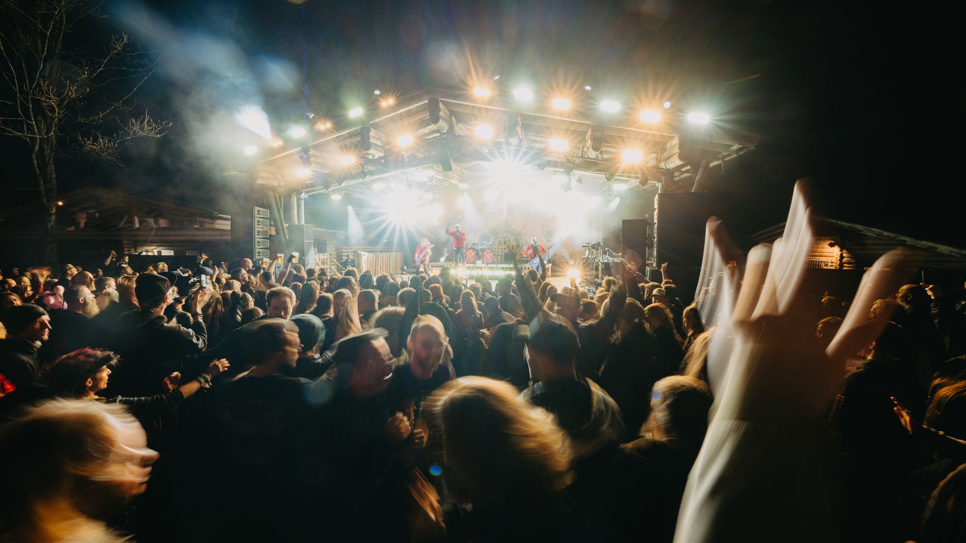 Full Metal Mayrhofen | Metal Festival in the Alps Concert crowd in front of a brightly lit stage at Full Metal Mayrhofen, with raised hands and an intense festival atmosphere. Night-time metal concert in an alpine setting in Mayrhofen.