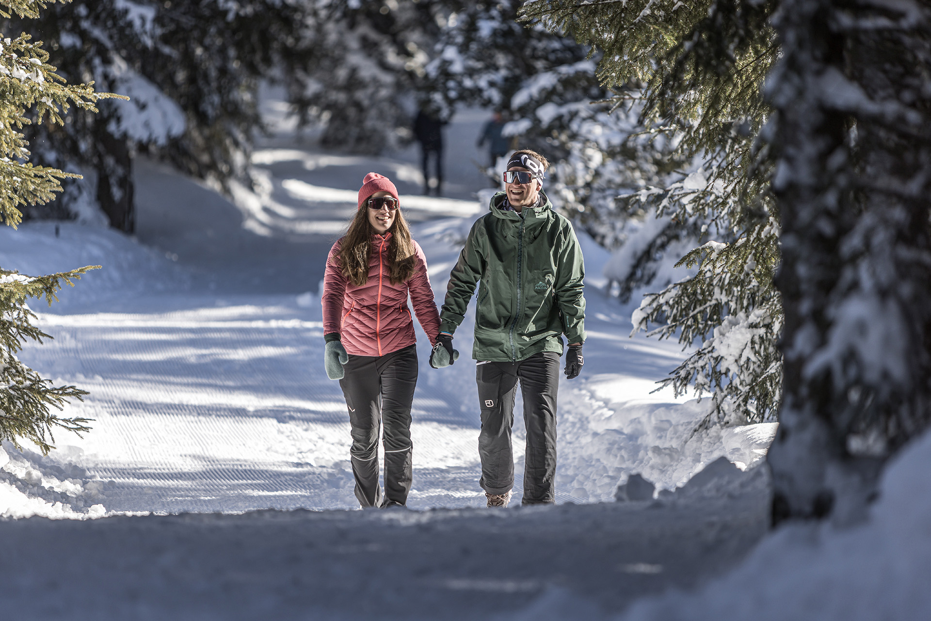 2 Personen wandern durch verschneiten Wald