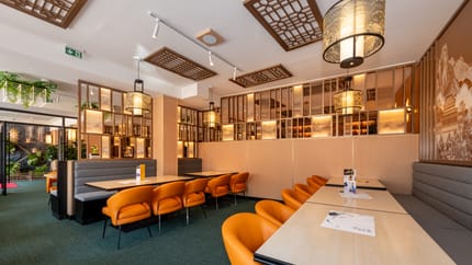 Restaurant mit hellbraunen Tischen und Stühlen