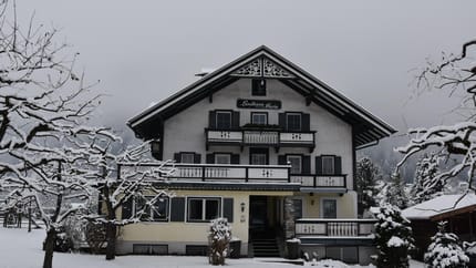 A multi-story house with snow-covered trees and garden, labeled 'Landhaus Maria'.