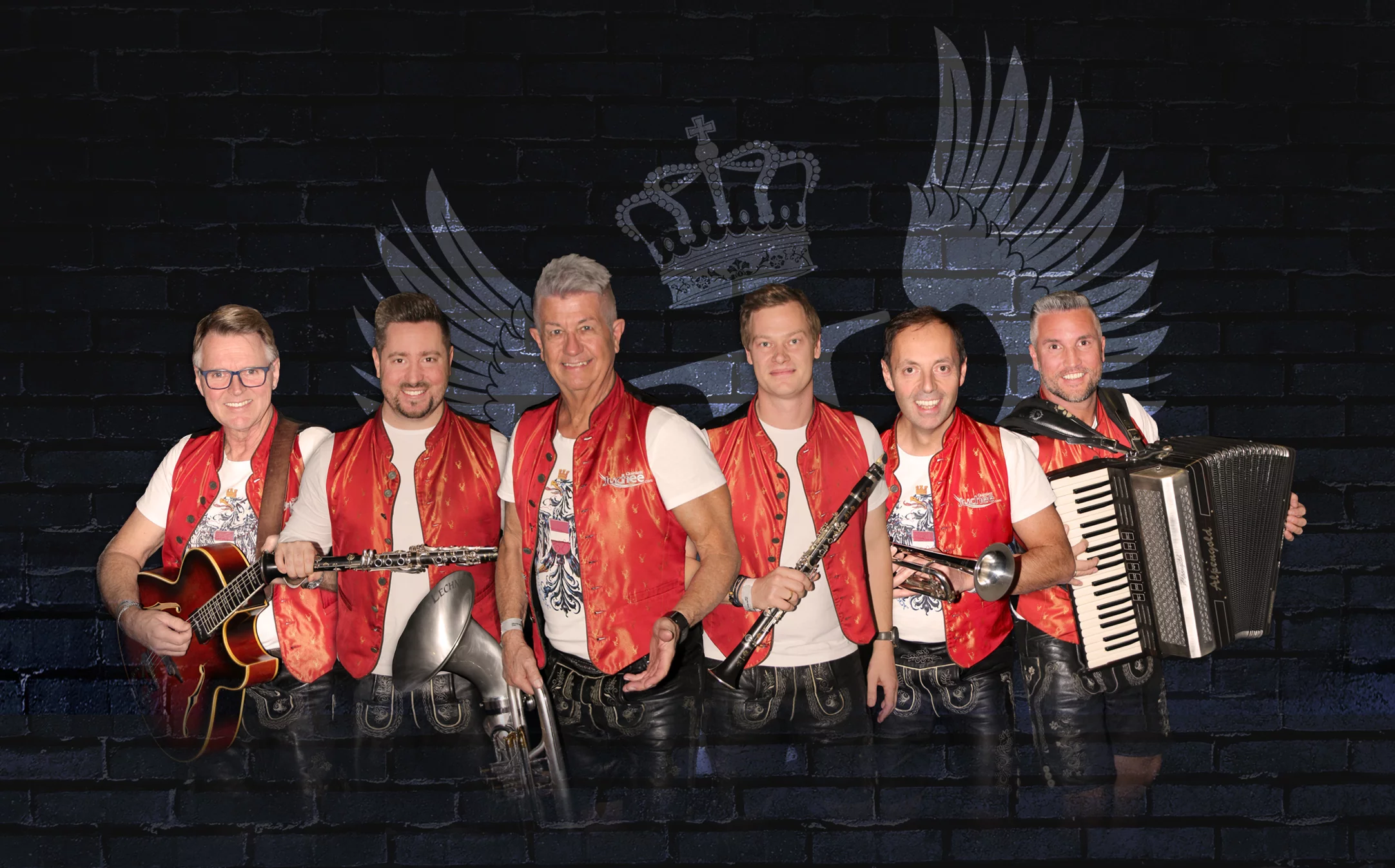 Das Bild zeigt ein Gruppenfoto des Qunintetts Juchee in roten Westen sowie den Musikinstrumenten.