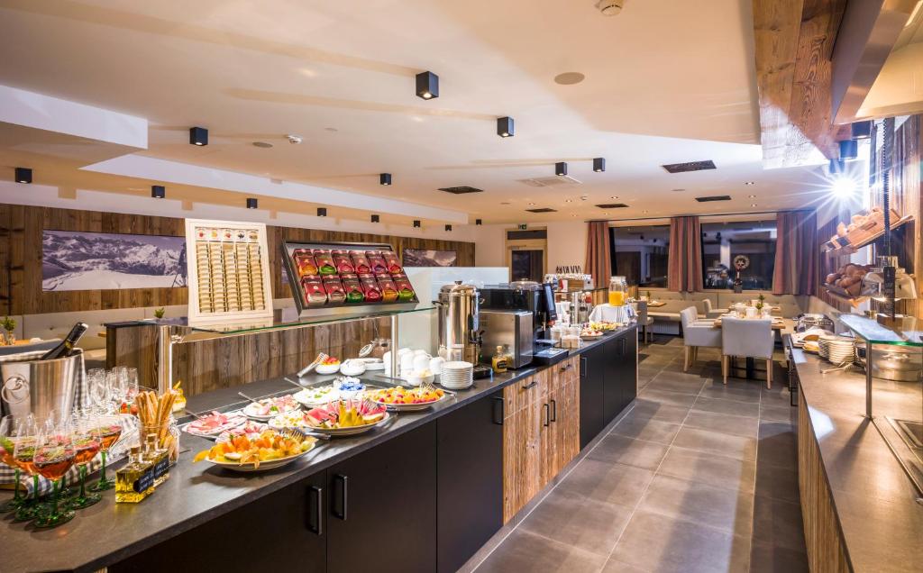 Breakfast buffet in a modern restaurant with coffee, fruit, and dishes on dark countertops, cozy setting.