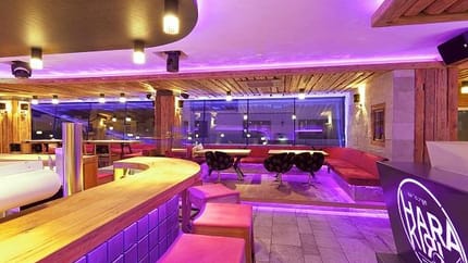 The image shows the Harakiri Bar illuminated by modern pink LED lights, creating a stylish and energetic ambiance.