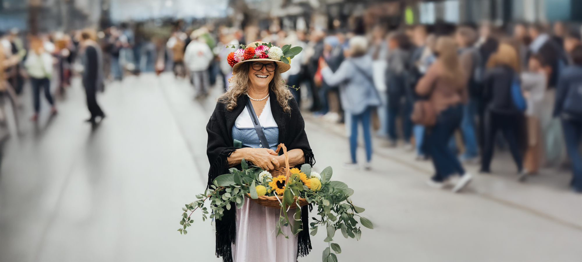 Frau im Dirndl mit Blumenkranz und Erntekorb auf einer belebten Straße beim Zillertaler Bauern- und Musikherbst in Mayrhofen.Frau im Dirndl mit Blumenkranz und Erntekorb auf einer belebten Straße beim Zillertaler Bauern- und Musikherbst in Mayrhofen.