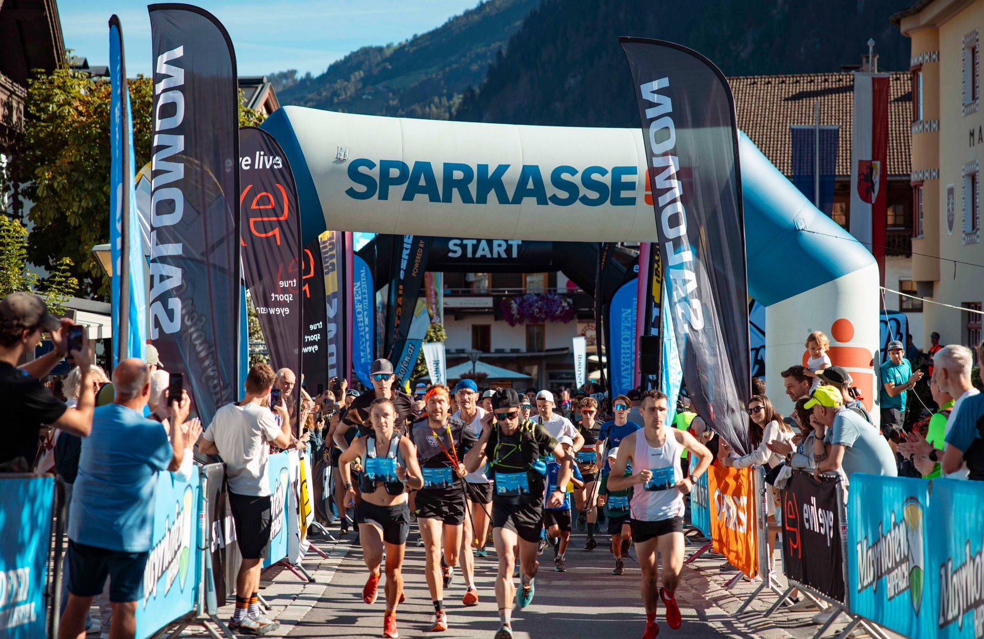 Start des Mayrhofen Ultraks Zillertal: Läuferinnen und Läufer starten im Ortszentrum von Mayrhofen unter dem Startbogen, begleitet von Zuschauern entlang der Strecke.