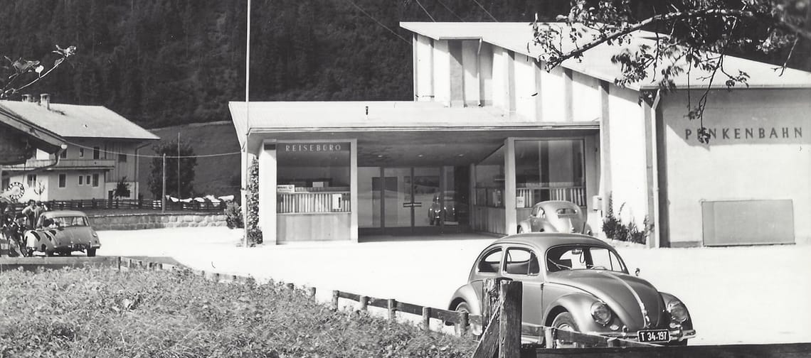 Black-and-white photo of a station with cars and a building, labeled Penkenbahn Mayrhofen, Tirol.