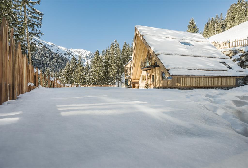 Das Bild zeigt ein Gebäude aus Holz in einer Winterlandschaft