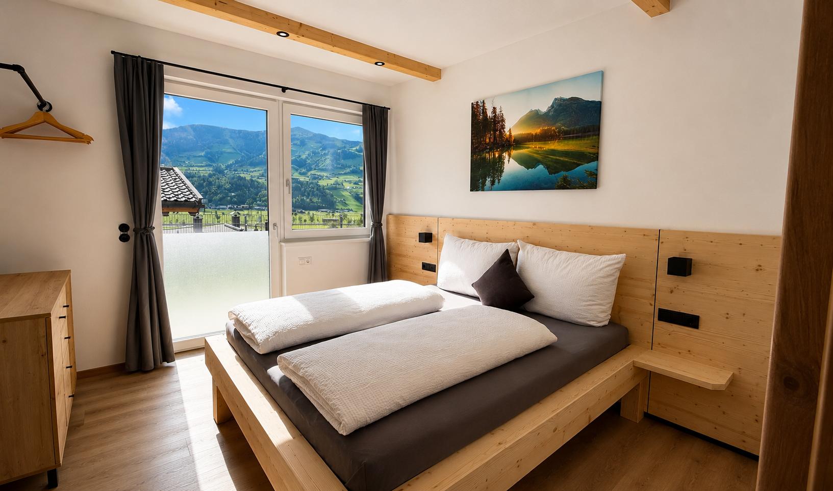 Schlafzimmer mit Holzbett, Blick auf Berge durch Fenster, Wandbild von See und Natur, dunkle Vorhänge, helle Wände.