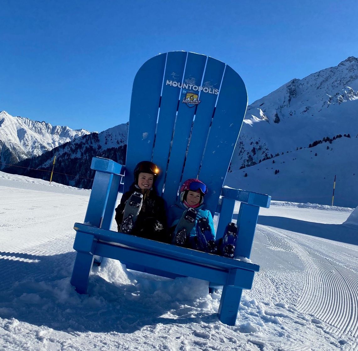 Ein riesiger, blauer Holzstuhl mit Kinder am Ahorn in Mayrhofen-Hippach