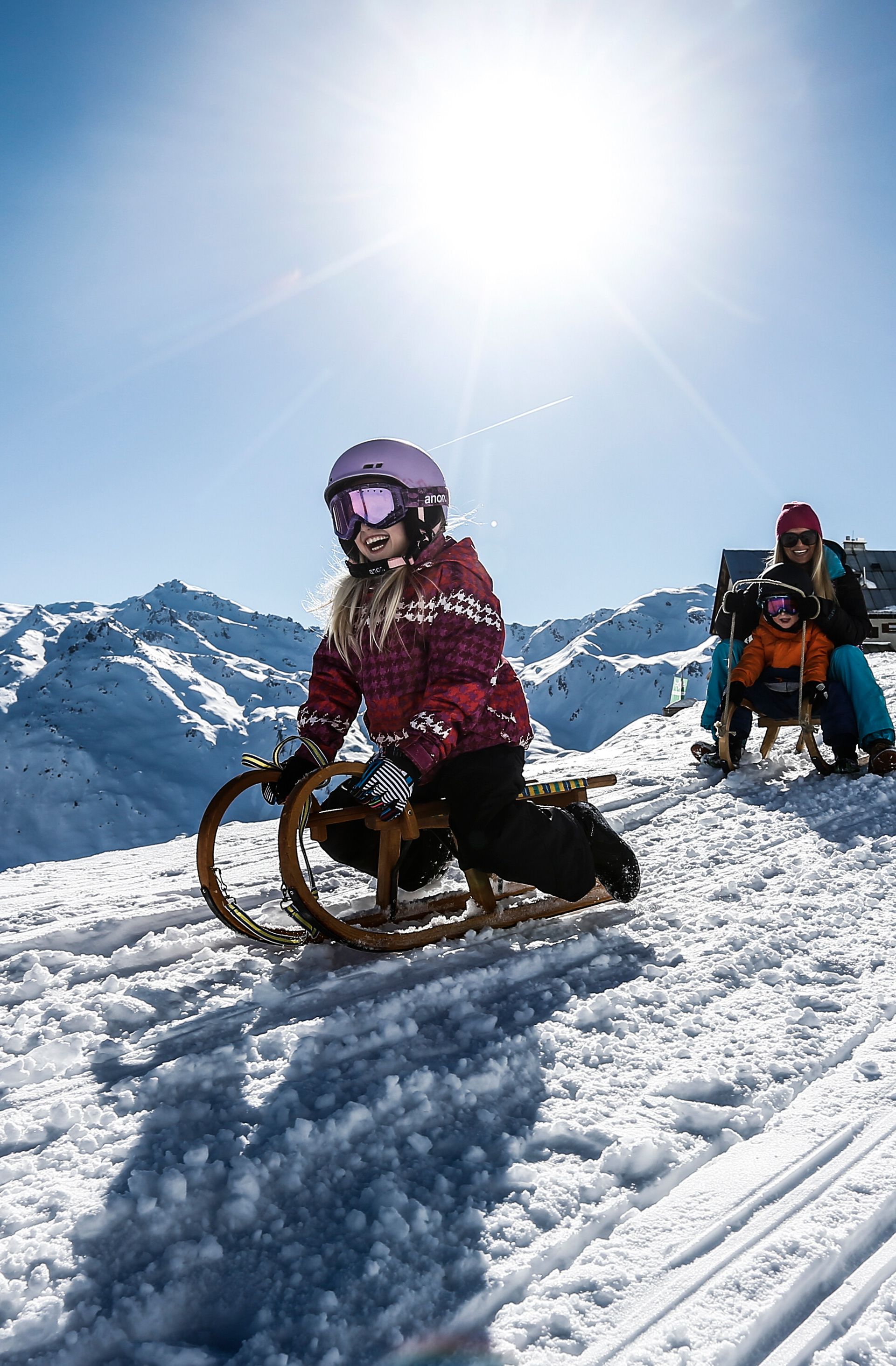 Rodelspaß auf der Rastkogel-Rodelbahn am Schwendberg bei Sonnenschein, mit Blick auf die verschneite Bergwelt – familienfreundliches Wintererlebnis in Mayrhofen-Hippach.