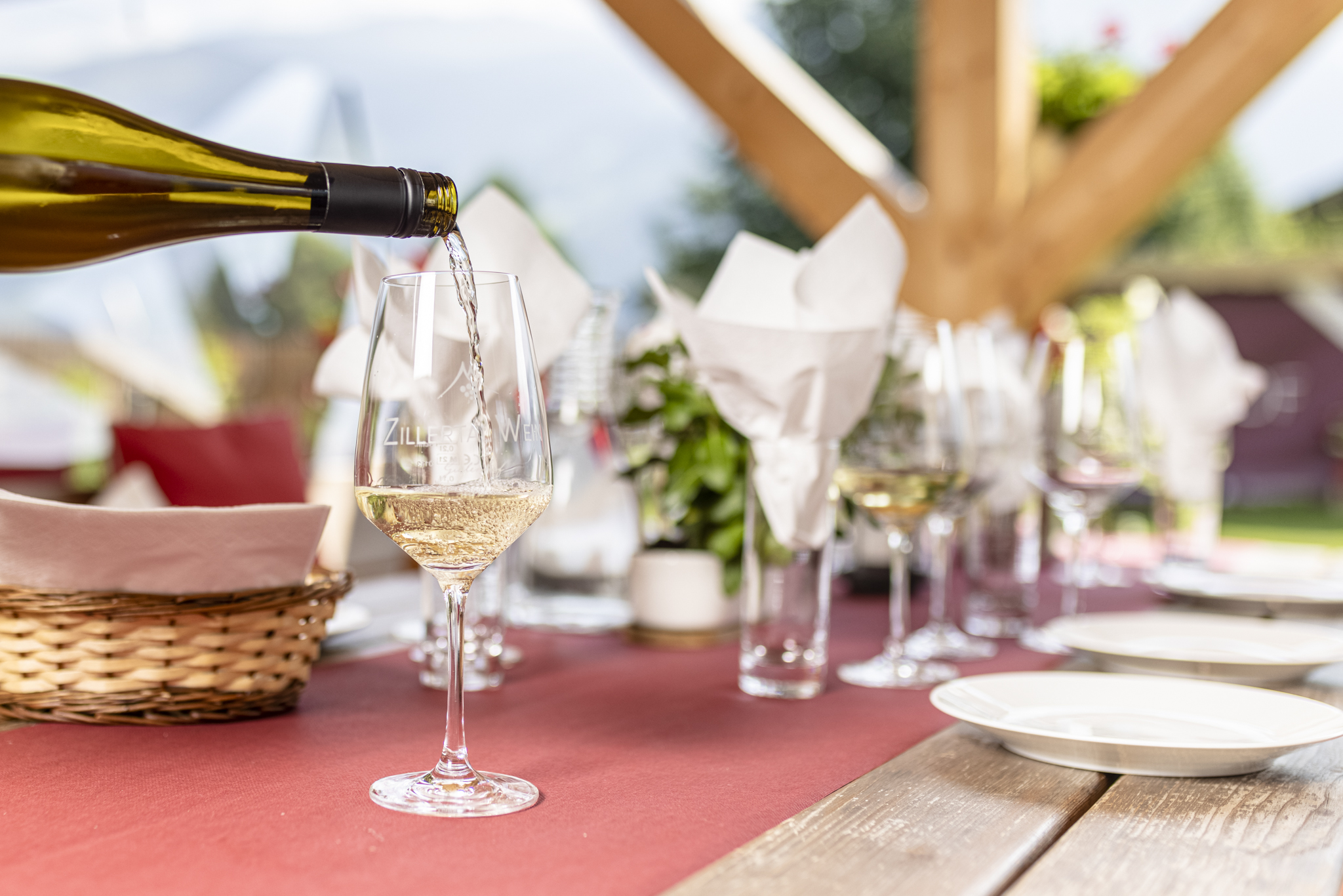 Wine glass with rosé wine on a decorated outdoor table.