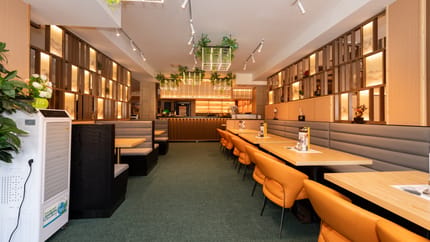 Restaurant mit hellbraunen Tischen und Stühlen