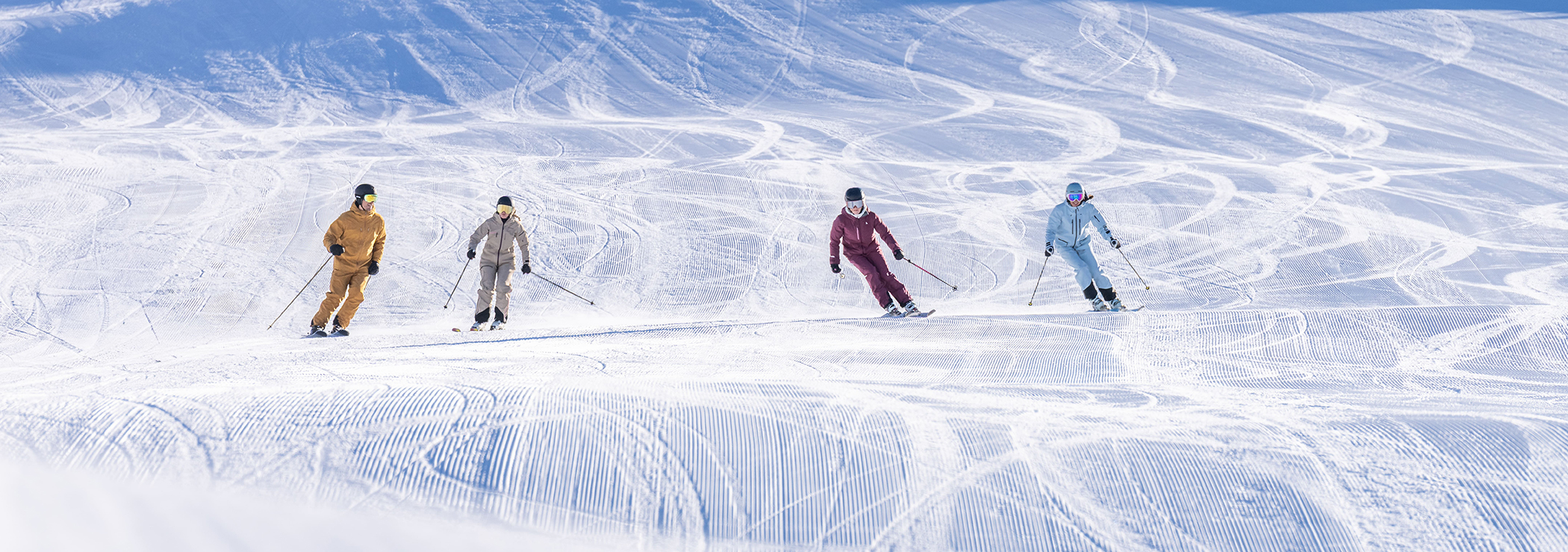 4 friends skiing at a perfectly groomed slopes