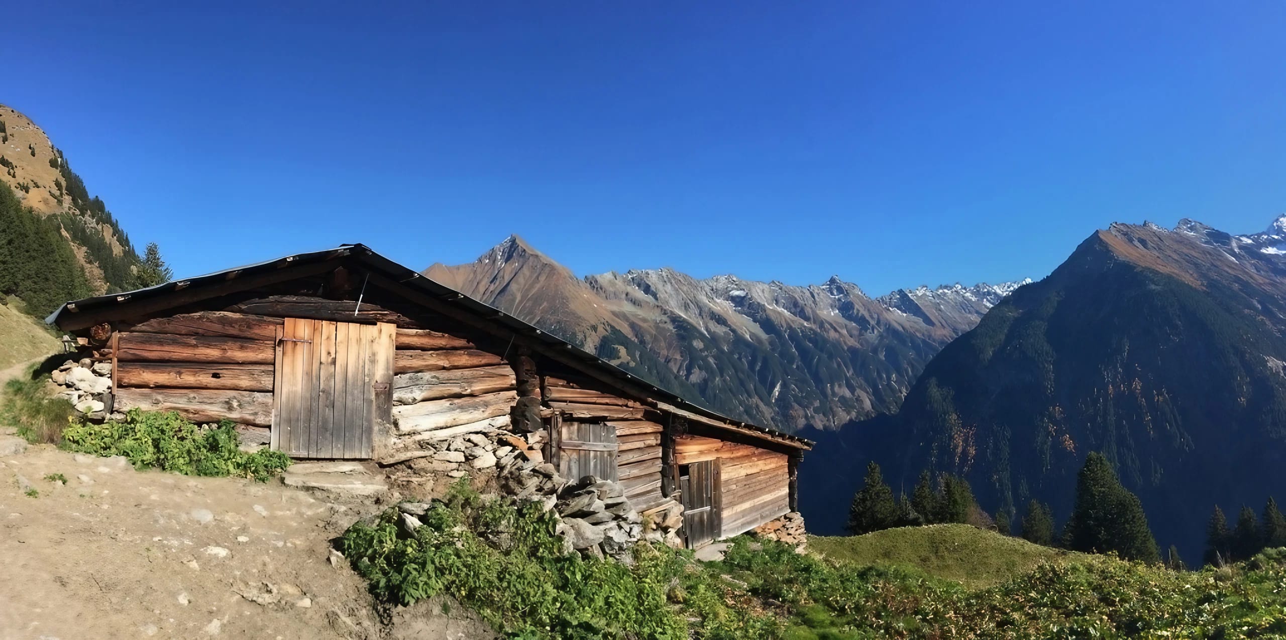 Eine alte Berghütte mit Berge im Hintergrund