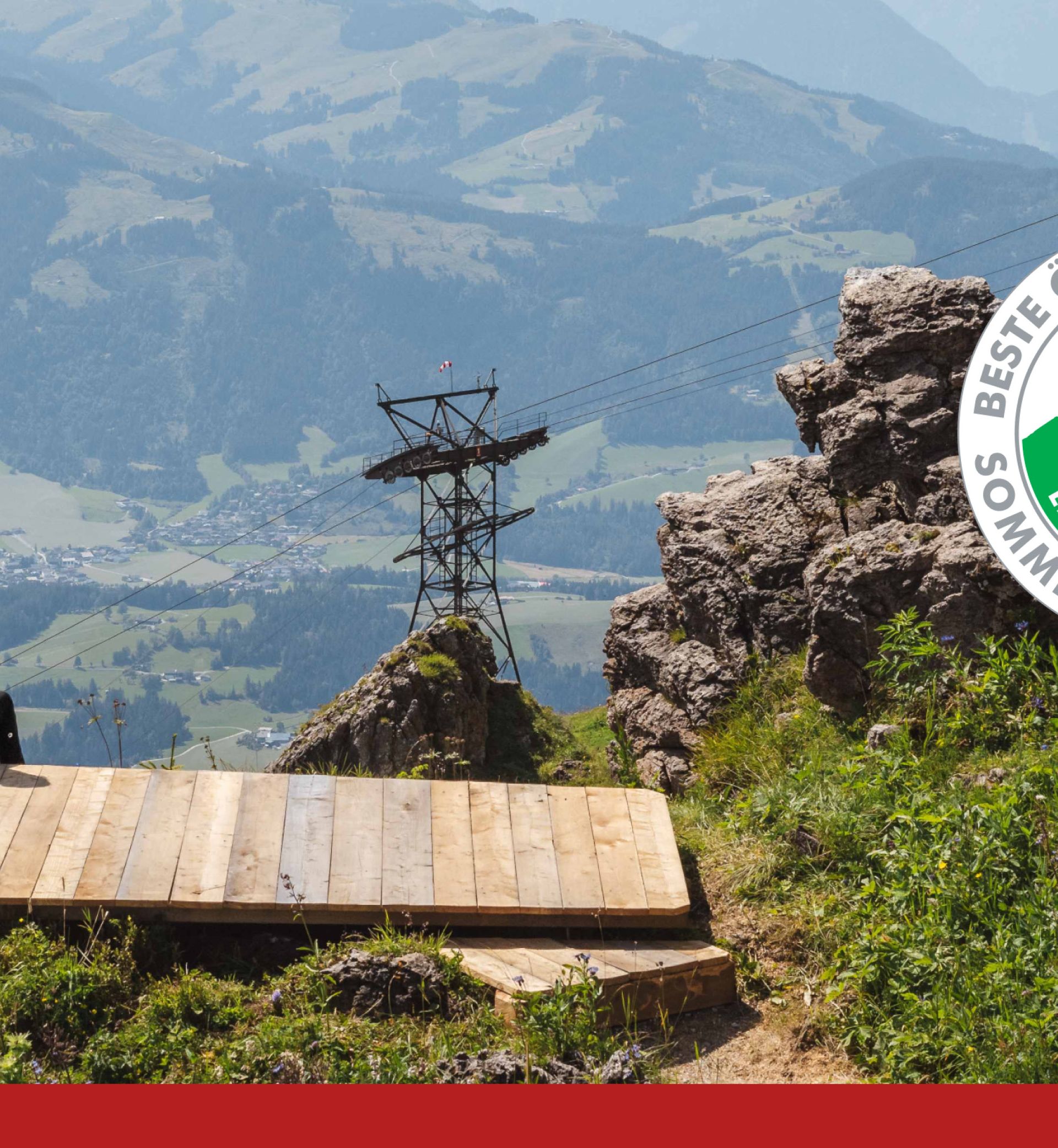 Couple sitting on a mountain with panorama and a cable car in the background