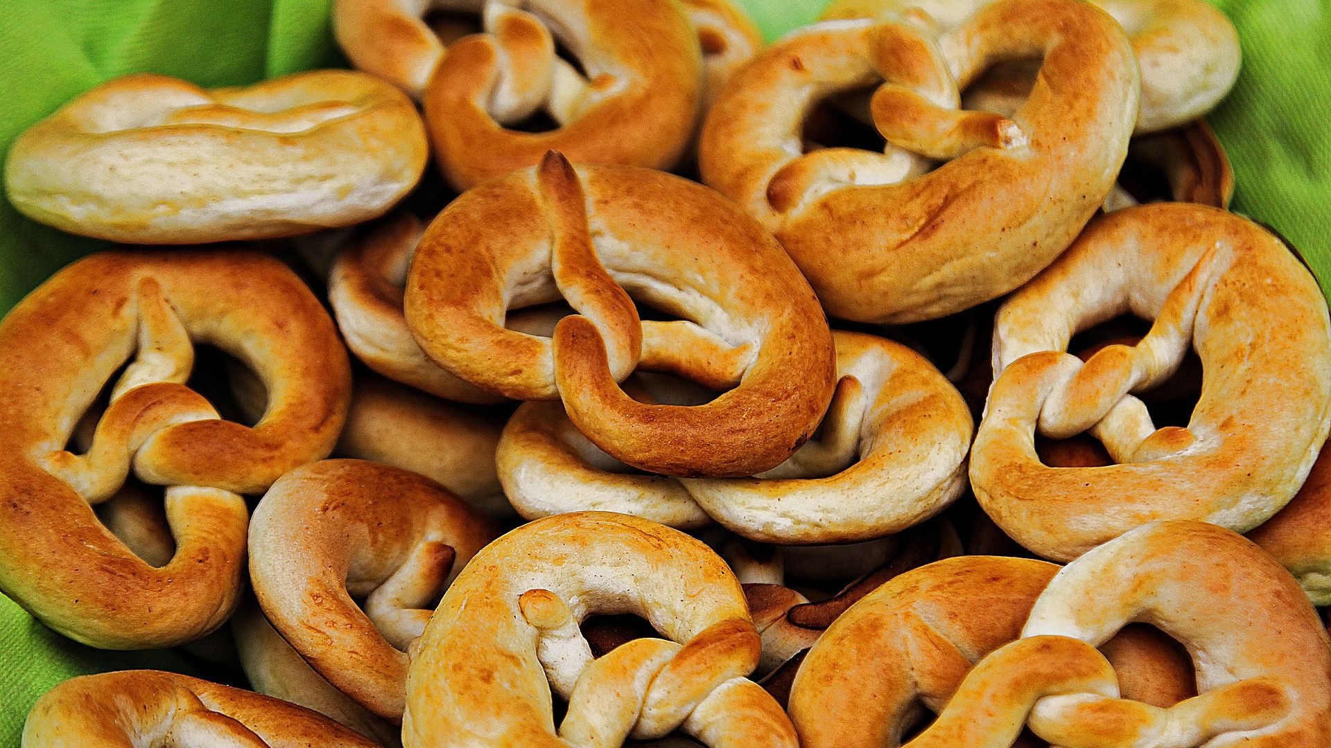 Traditional palm pretzels from the Zillertal region, freshly baked and arranged on a green cloth.