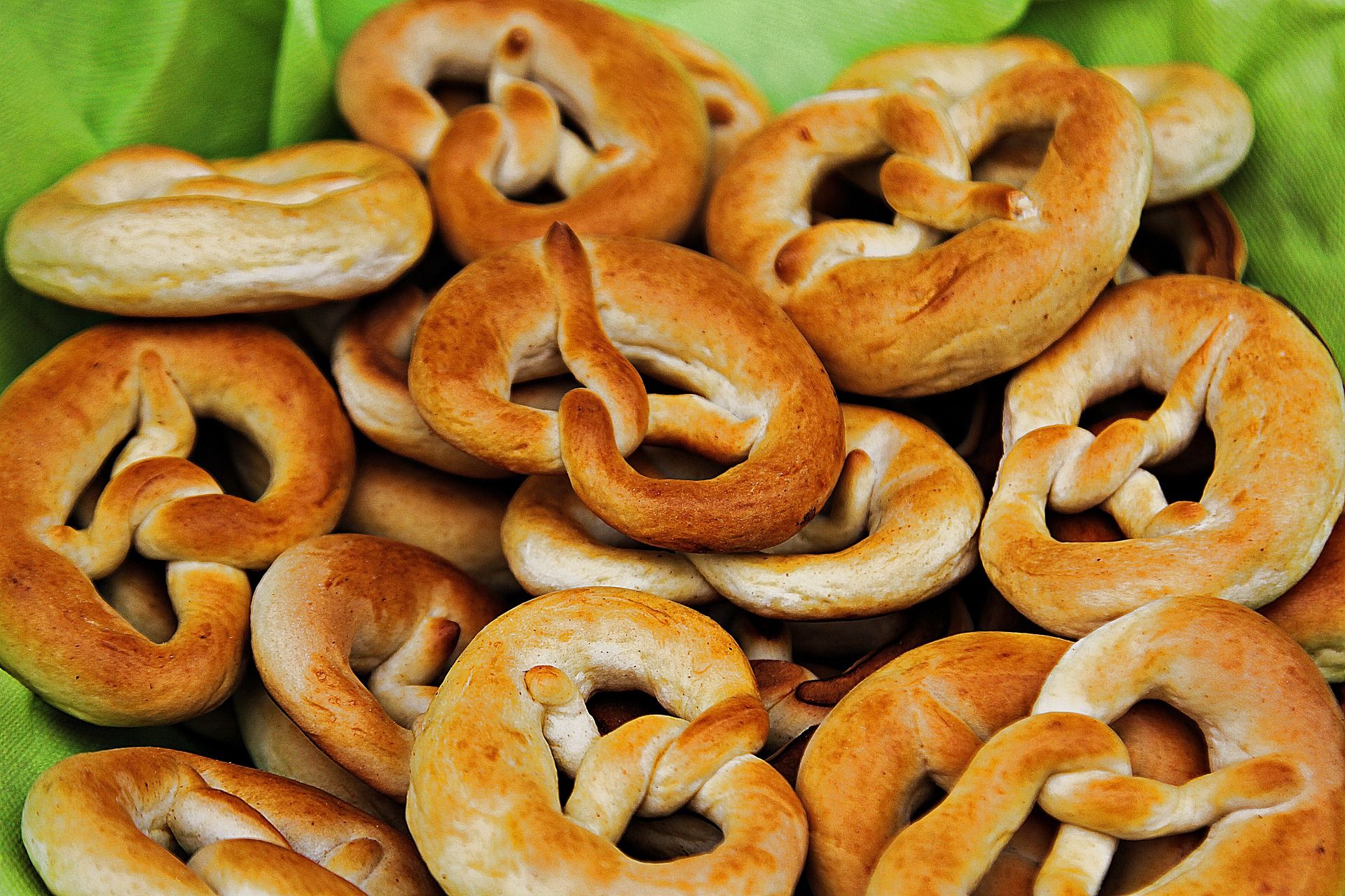 Traditionelle Palmbrezen aus dem Zillertal, frisch gebacken und auf einem grünen Tuch angerichtet.