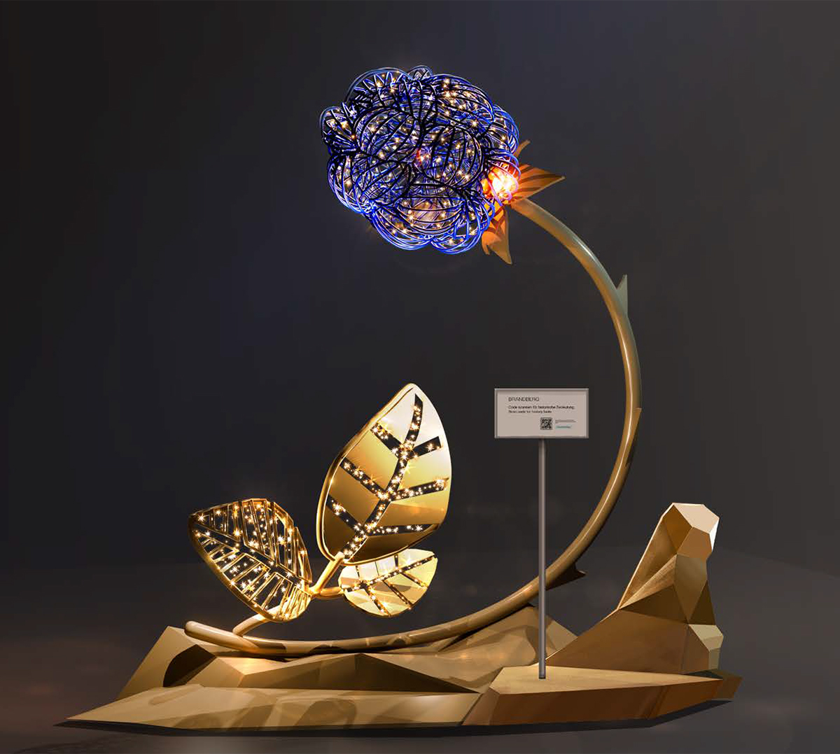 Beleuchtete Kunstinstallation in Brandberg (Tirol): stilisierte Beere mit leuchtenden Punkten auf gebogenem Stiel, davor große goldene Blätter auf einer abstrakten Basis; modernes Lichtobjekt vor dunklem Hintergrund.