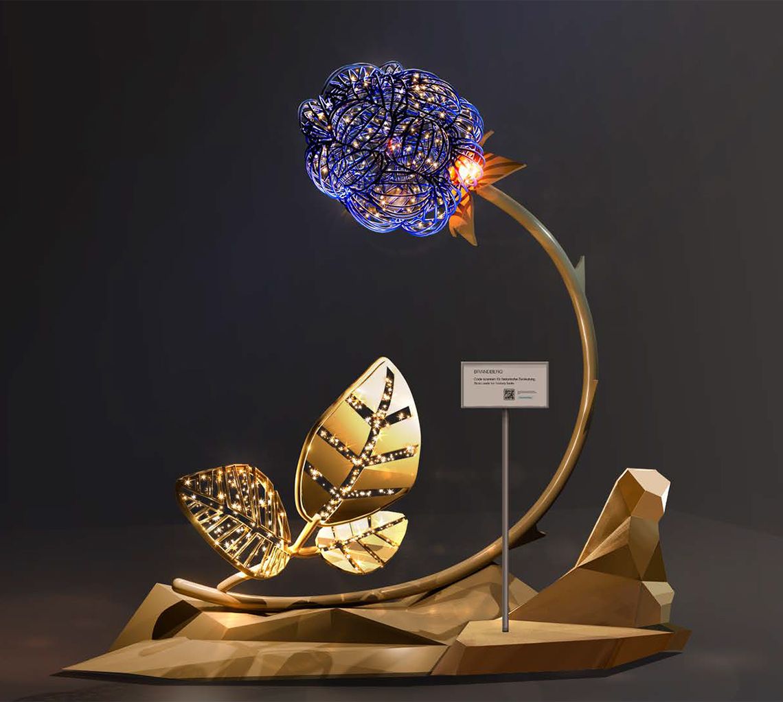 Beere Brandberg – beleuchtete Skulptur bei Nacht Beleuchtete Kunstinstallation in Brandberg (Tirol): stilisierte Beere mit leuchtenden Punkten auf gebogenem Stiel, davor große goldene Blätter auf einer abstrakten Basis; modernes Lichtobjekt vor dunklem Hintergrund.