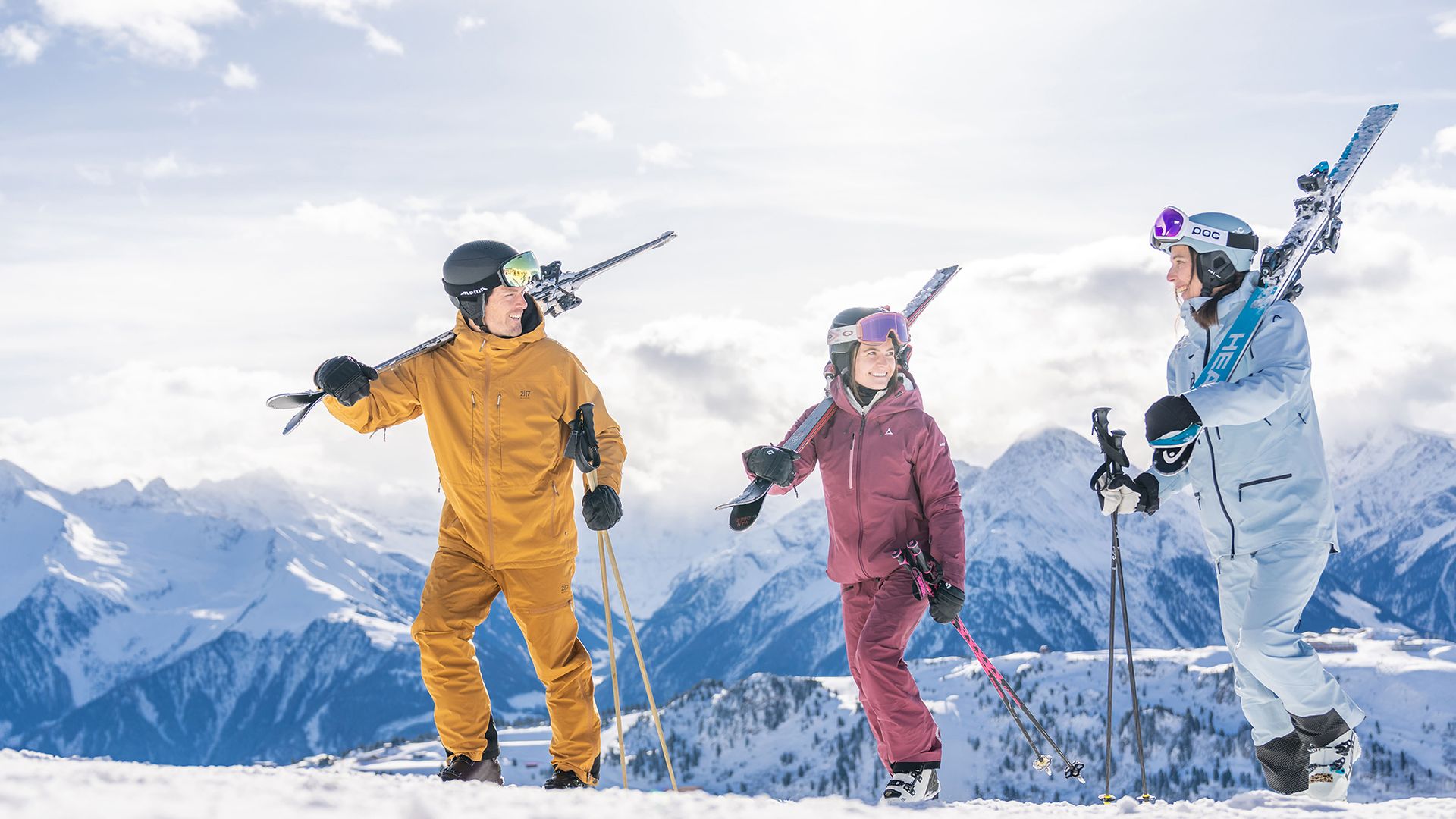 Freunde mit Skiern vor einem herrlichen Panorama