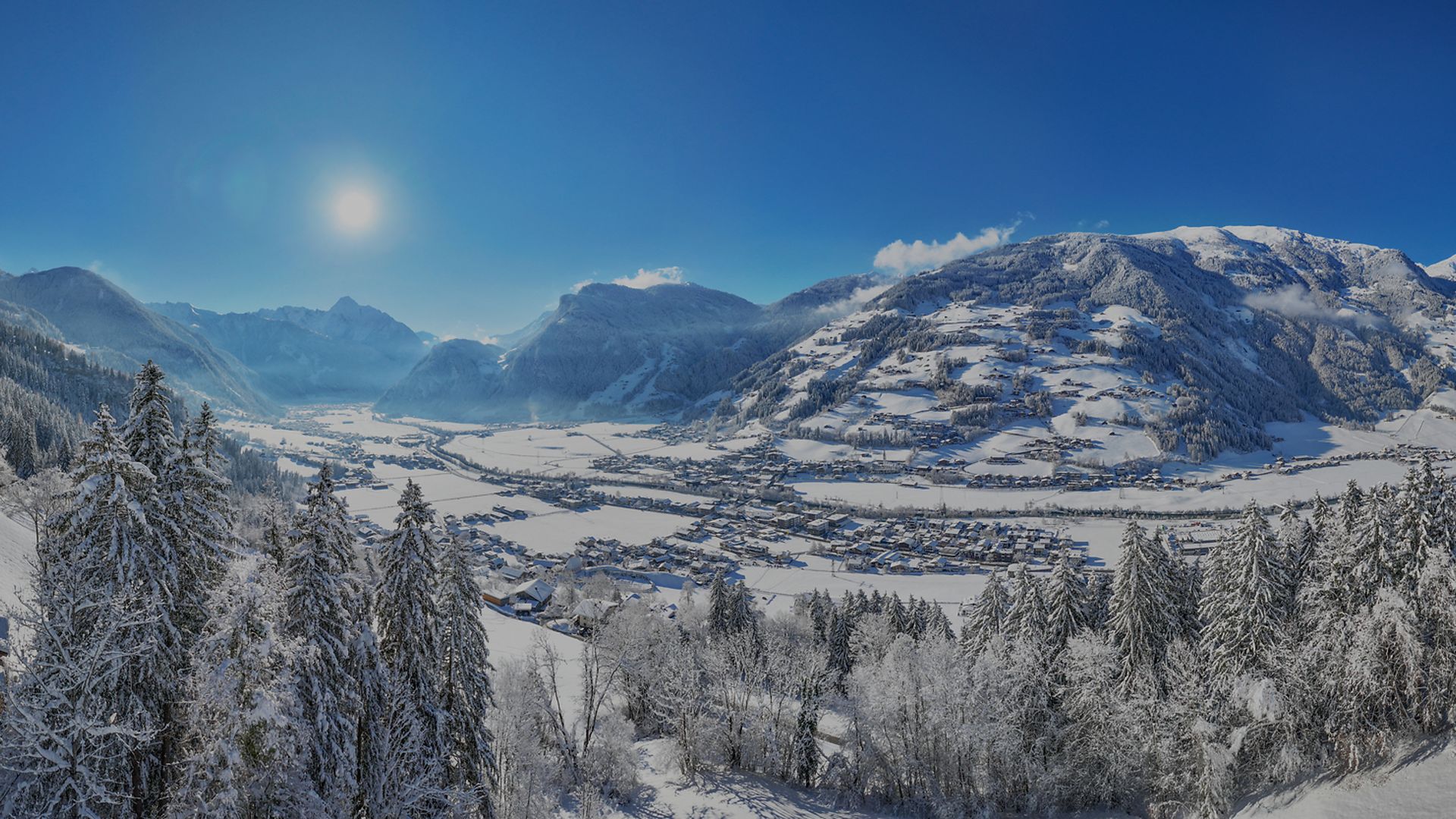 Winterurlaub im Zillertal Winterlandschaft im Zillertal: Schneebedeckte Berge, strahlender Sonnenschein und ein malerisches Tal mit verschneiten Bäumen. Perfektes Panorama für Wintersport und Erholung.