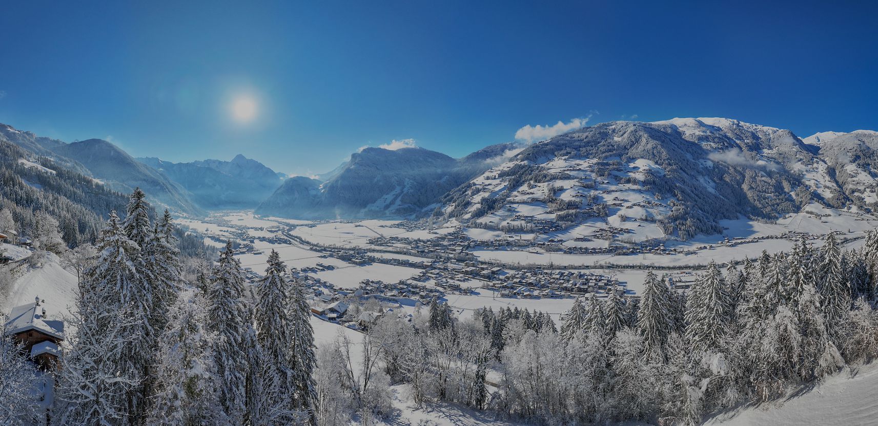 Winter vacation in Zillertal Winter landscape in Zillertal: Snow-covered mountains, bright sunshine, and a picturesque valley with snowy trees. A perfect panorama for winter sports and relaxation