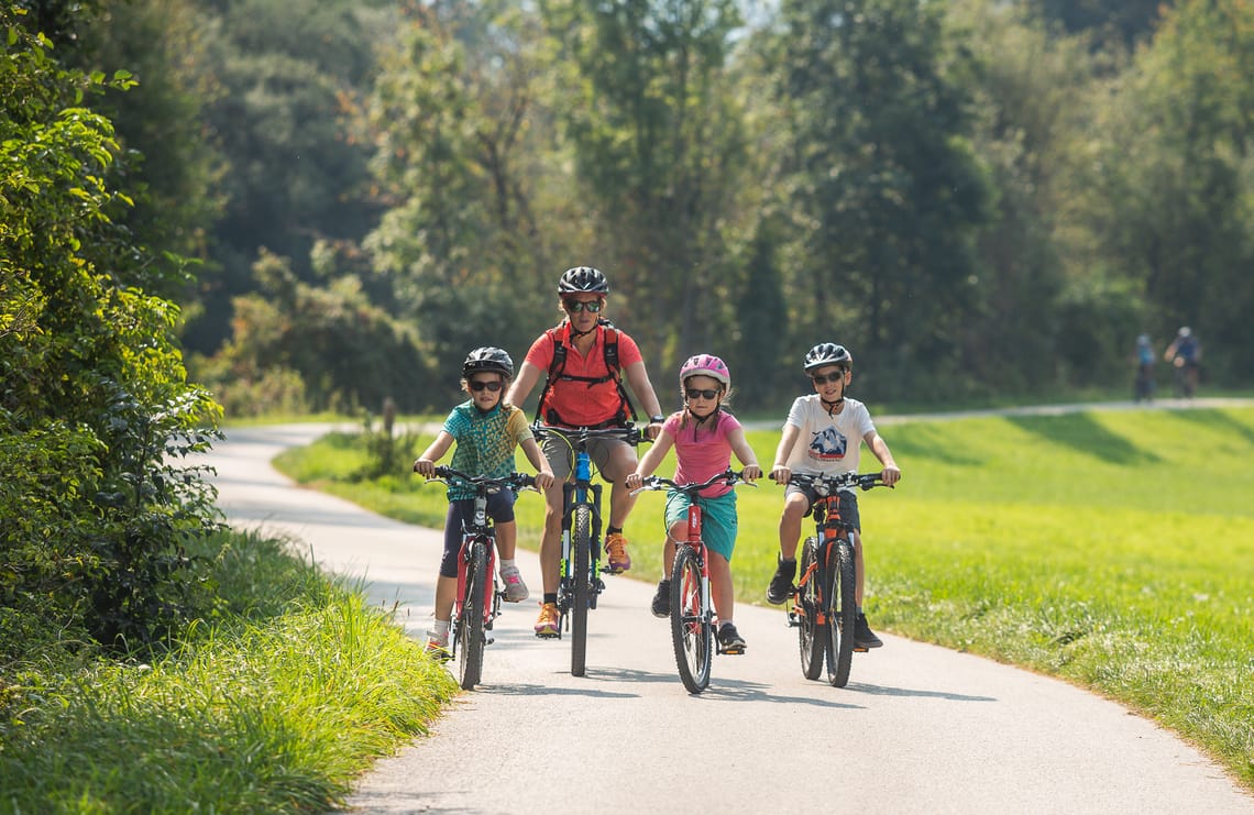 Zillertalradweg - Biken mit der Familie Familie mit Kindern beim Radfahren auf dem Zillertal Radweg in Tirol bei sonnigem Wetter inmitten der Natur.