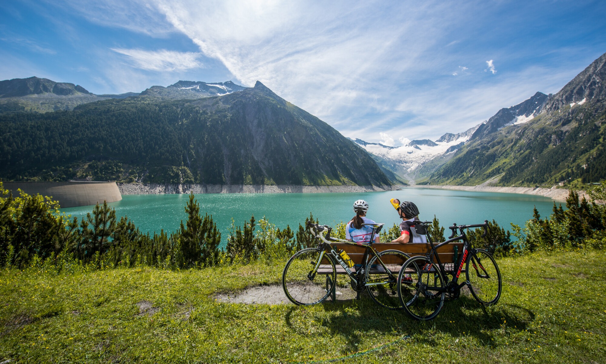 Cyclists take a break on a bench at the Schlegeis Reservoir.