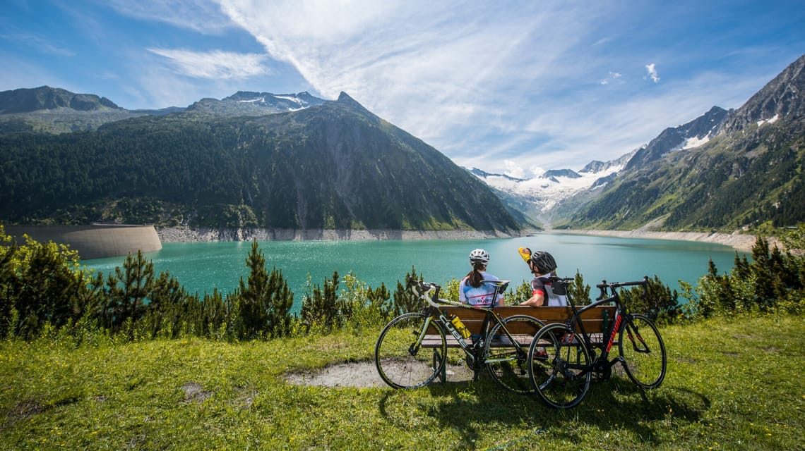 Cyclists take a break on a bench at the Schlegeis Reservoir.