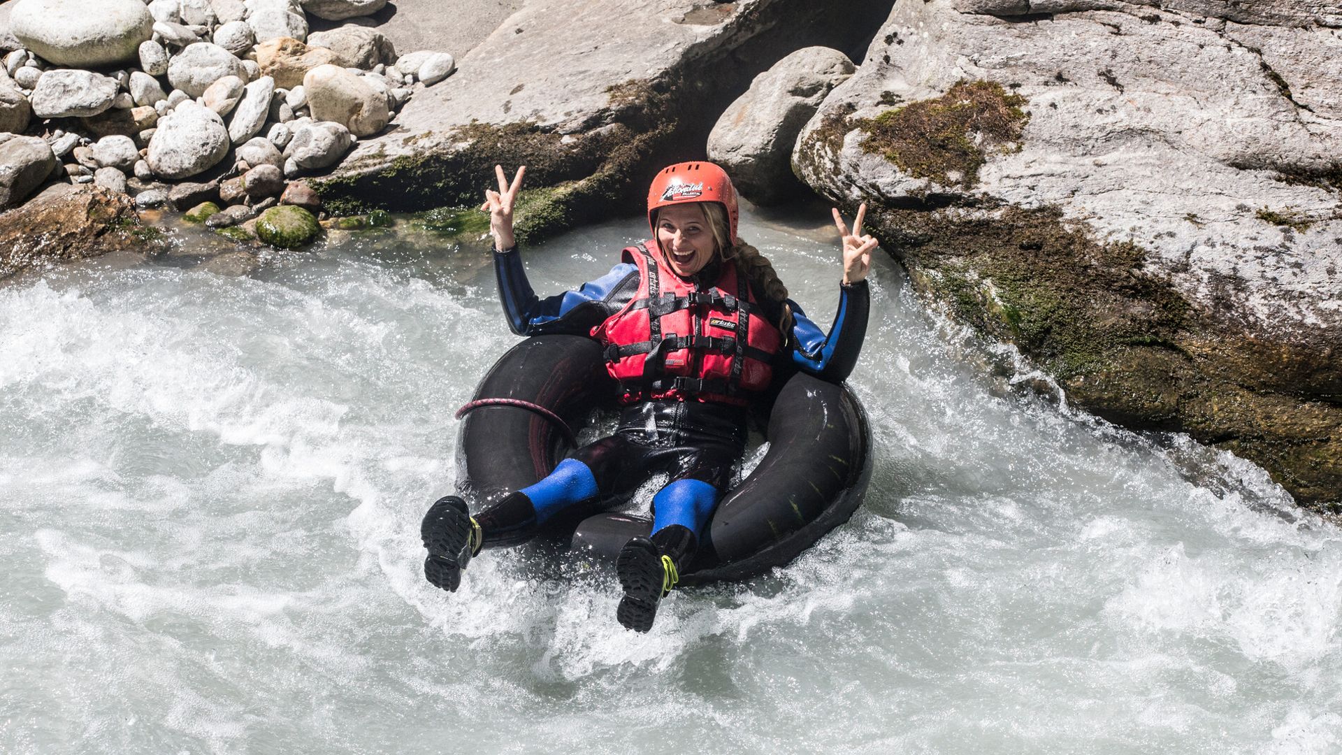 Person wearing a helmet and life vest tubing on a whitewater stream in Mayrhofen-Hippach in Zillertal.