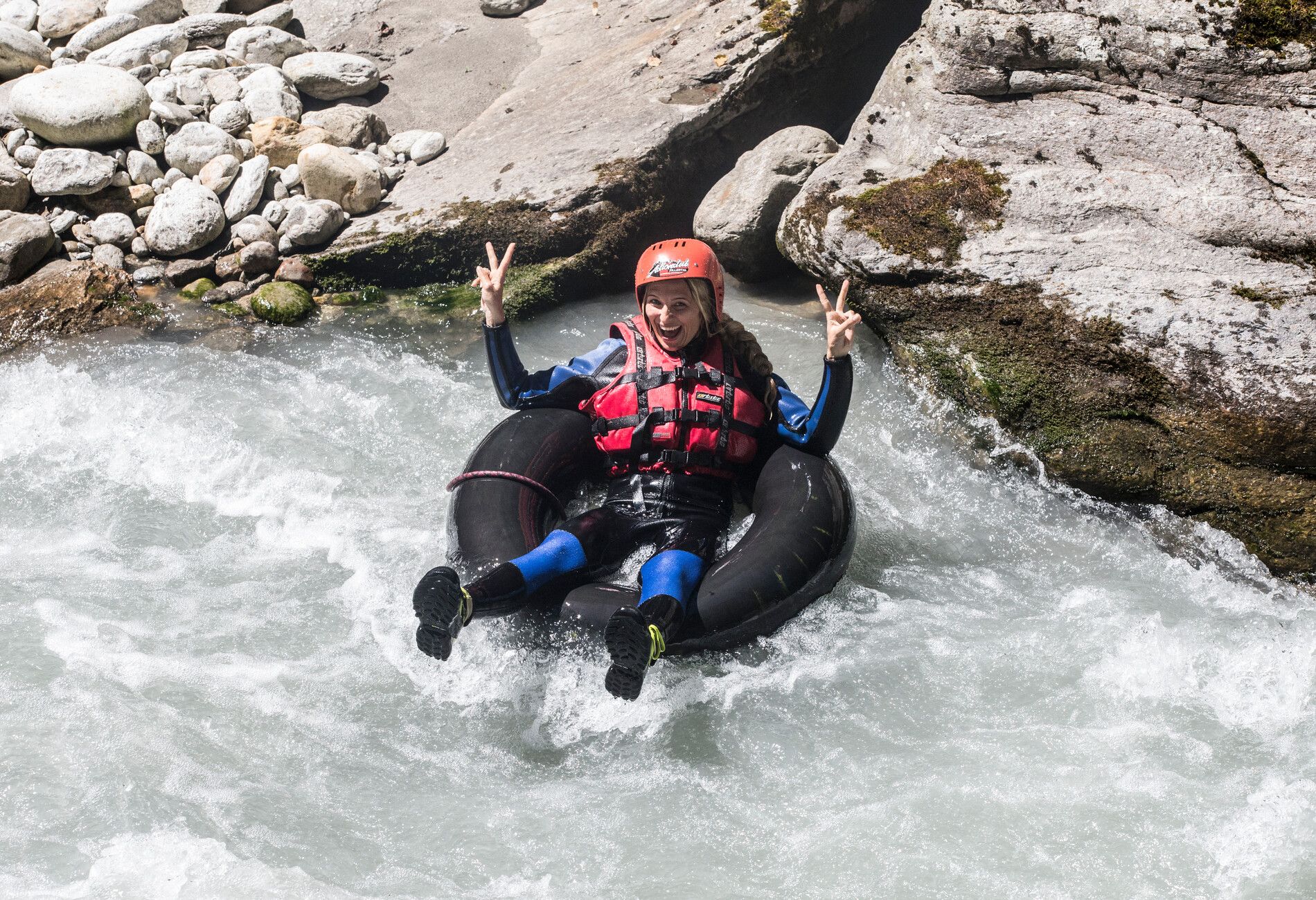 Person wearing a helmet and life vest tubing on a whitewater stream in Mayrhofen-Hippach in Zillertal.