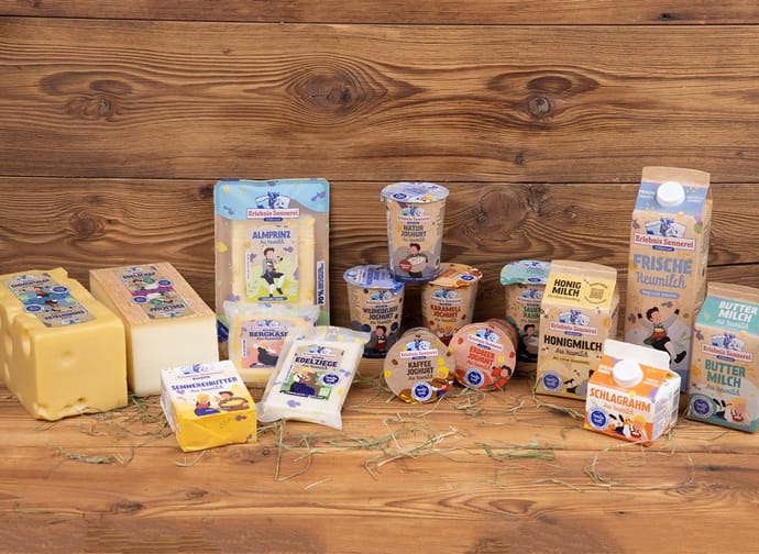 Verschiedene Milchprodukte und Joghurts auf einem Holztablett, verpackt mit bunten Etiketten und Illustrationen.