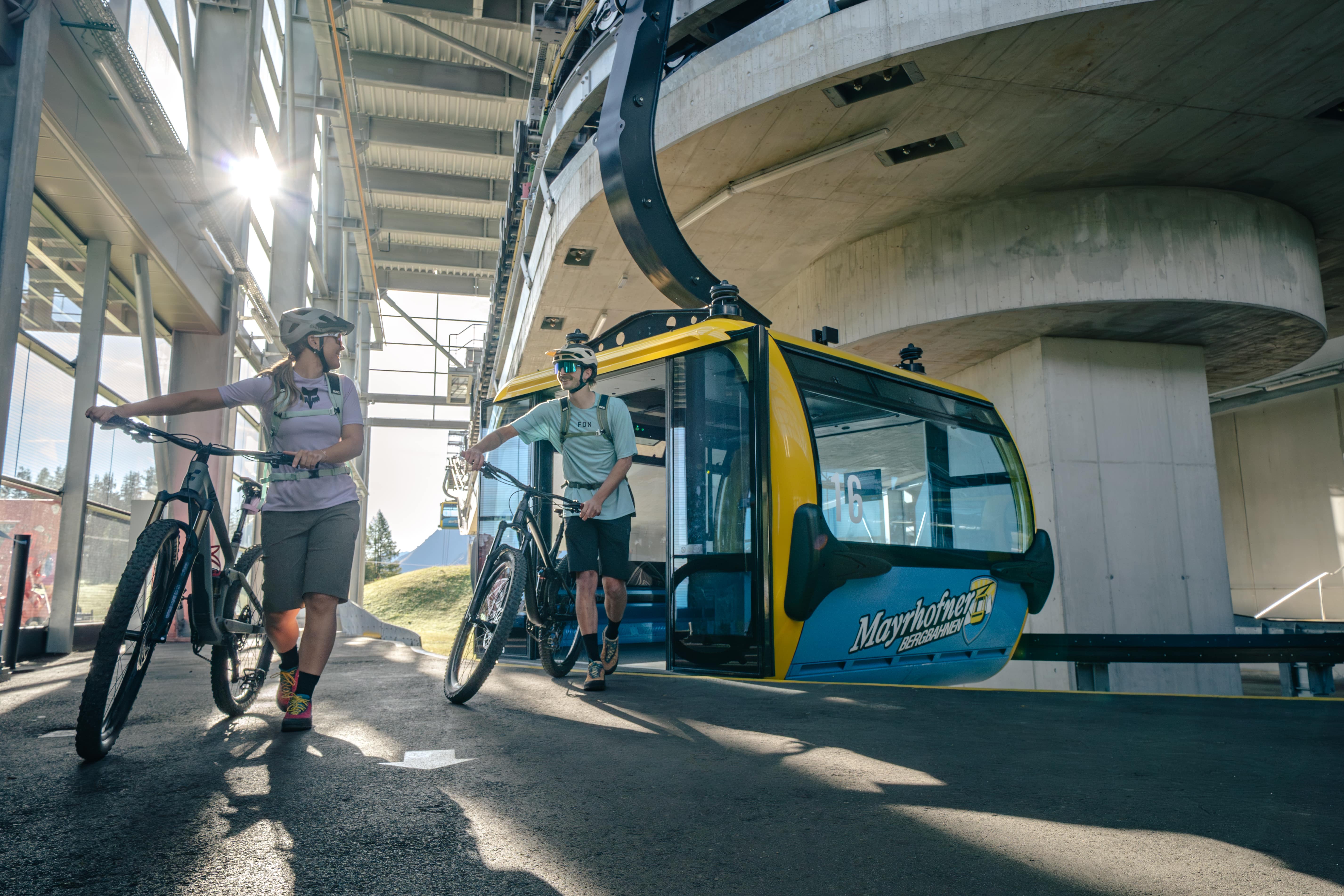 Paar steigt mit dem Fahrrad aus der Gondel aus