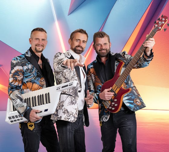 The image shows the music group “Die Grubertaler” with their instruments in front of a colorful background.