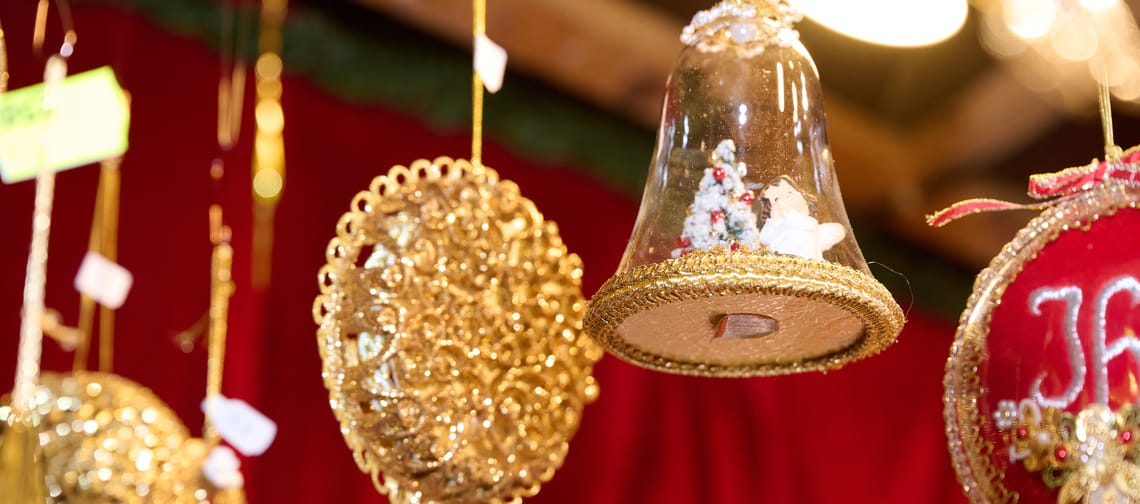 The picture shows golden Christmas decorations on a red background.