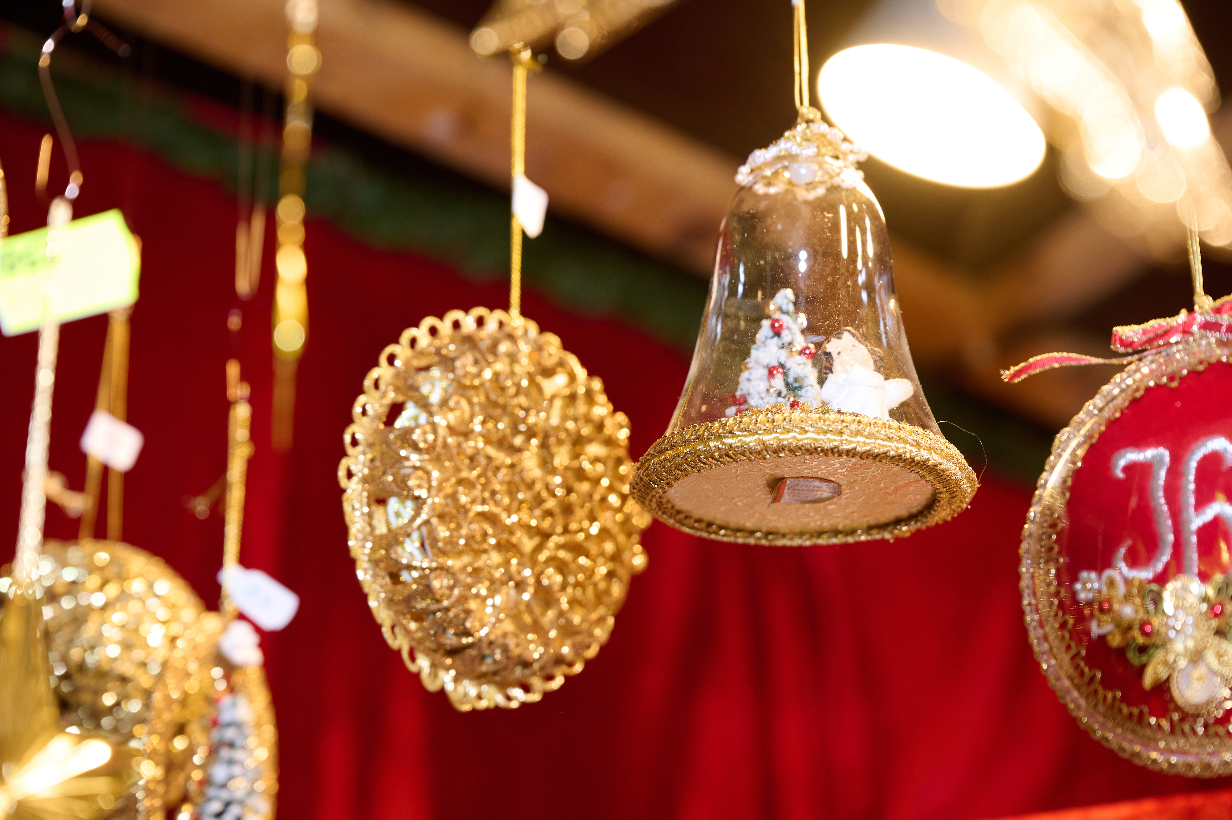 The picture shows golden Christmas decorations on a red background.