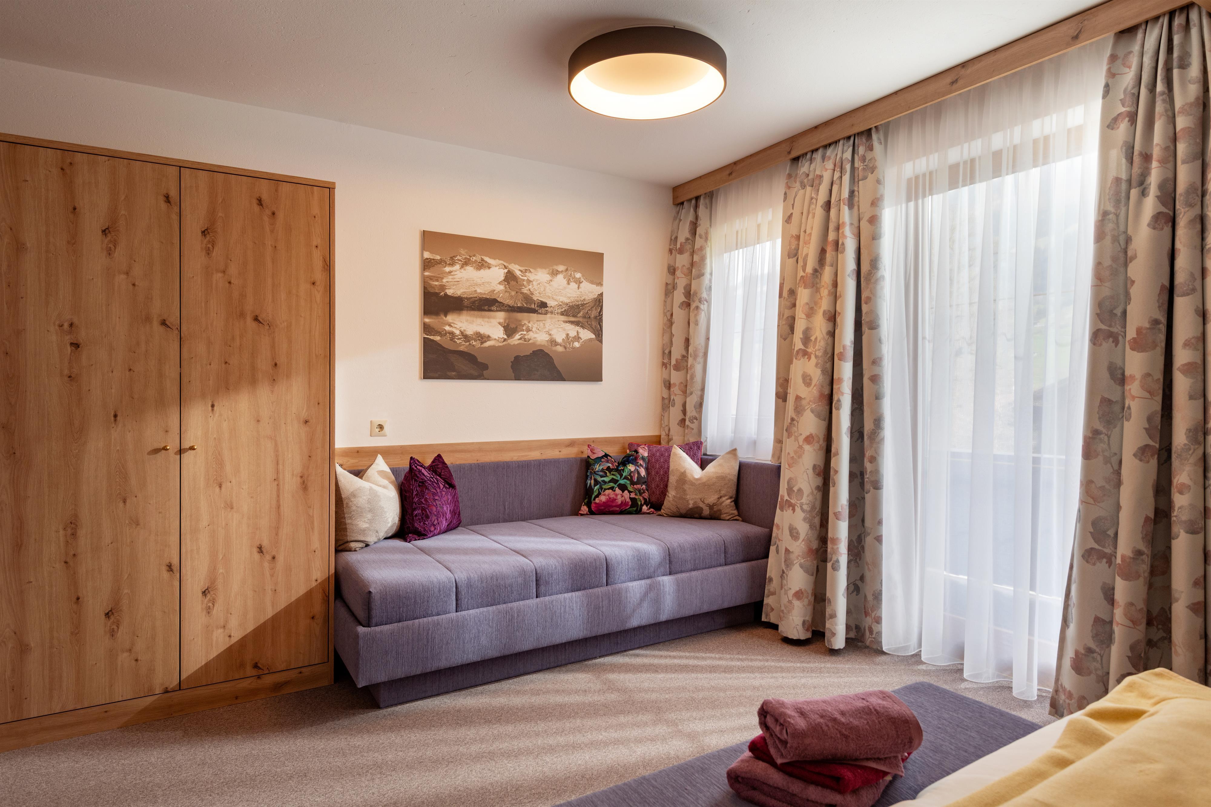feratel-Landhaus Gredler - Apart Tirol Zimmer 1 mit Bild von der Schlafcouch